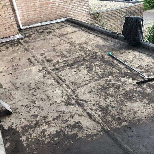 Schoonmaken van een plat dak in Dongen